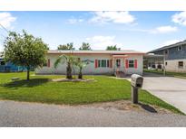 Charming single-story home with vibrant landscaping, brick facade, and covered parking at 24538 Wildhog Rd, Astor, FL 32102