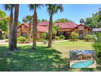 Stunning one-story home with a red tile roof, mature landscaping, and a beautiful lawn at 3513 Kilgallen Ct, Ormond Beach, FL 32174
