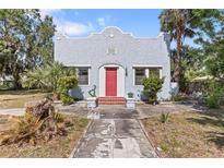 Charming single-story home featuring a stucco exterior, red door, and well-maintained landscaping at 509 Park Dr, Daytona Beach, FL 32114
