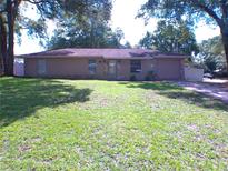 Charming one-story home with a well-maintained lawn and mature trees at 601 E Tall Pine Ter, Deland, FL 32724