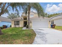Charming two-story home with a well-manicured lawn and a spacious two-car garage at 1305 Rebecca Dr, Haines City, FL 33844