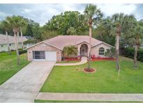 Beautiful brick home with a well-manicured lawn and mature palm trees adding to the curb appeal at 4622 Secret River Trl, Port Orange, FL 32129