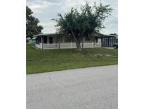 Charming home featuring a well-maintained front yard and inviting curb appeal with lovely green grass and mature trees at 9393 Sw 102Nd Pl, Ocala, FL 34481