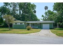 Charming single-story home with green exterior, attached garage, and well-maintained lawn at 1301 Oakwood Ave, Daytona Beach, FL 32114
