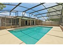 Inviting screened-in pool area features a clear blue pool and ample patio space for outdoor relaxation and entertainment at 2468 Scottville Ave, Deltona, FL 32725