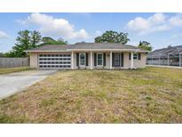 Charming single-story home featuring a unique garage door and well-maintained lawn at 290 Greenwood Cir, Ormond Beach, FL 32174