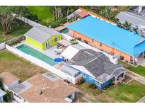 Aerial view of colorful homes, showcasing the backyard pool, hot tub and outdoor lounge area, all enclosed by a white fence at 342 Euclid Ave, Daytona Beach, FL 32118