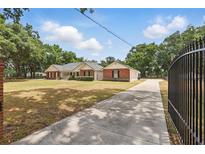 Gated brick home with a long driveway and a well-maintained front yard at 5865 Ross Creek Rd, Lakeland, FL 33810