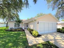 Charming single-story home with a two-car garage, a well-manicured lawn, and lush landscaping at 613 Clairmont Ln, South Daytona, FL 32119