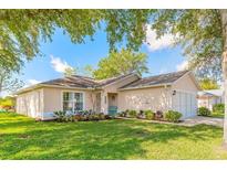 Charming single story home with a well-manicured lawn and attractive landscaping at 613 Clairmont Ln, South Daytona, FL 32119