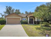 Charming home with a two-car garage, well-maintained lawn, and inviting front entrance with decorative columns at 881 Westline Ave, Deltona, FL 32725