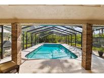 Inviting screened-in pool features clear blue water, ample sunlight, and outdoor greenery at 1 Crooked Bridge Way, Ormond Beach, FL 32174