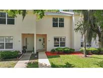 Charming townhome featuring a welcoming front facade with a well-manicured lawn and verdant shrubbery at 1502 Deer Springs Rd, Port Orange, FL 32129