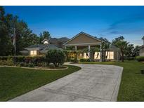 Stunning home with a long driveway, well-manicured lawn, and beautiful landscaping at 1766 Roscoe Turner Trl, Port Orange, FL 32128