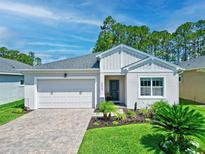 Charming single-story home with a well-manicured lawn, brick driveway, and attached two-car garage at 5539 Estero Loop, Port Orange, FL 32128