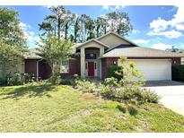 Charming single-story brick home with a well-manicured lawn and a bright red front door at 16 Hunt Master Ct, Ormond Beach, FL 32174