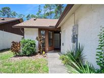 Inviting front entrance with well-maintained landscaping and a charming, light-colored exterior at 915 Stonybrook Cir, Port Orange, FL 32127