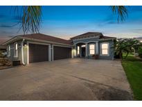 Charming home featuring a three-car garage, a well manicured lawn and lovely tropical landscaping at 3345 Tesoro Cir, New Smyrna Beach, FL 32168