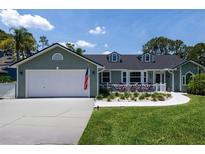 Charming single-story home with a spacious driveway, two-car garage, and a quaint front porch at 516 Spotted Sandpiper Dr, Daytona Beach, FL 32119