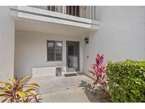 Welcoming entrance with a screen door, window, and beautiful plants at 1 Tomoka Oaks Blvd # 135, Ormond Beach, FL 32174