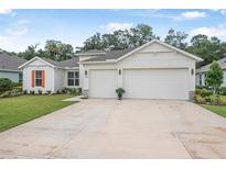 Charming single-story home featuring a three-car garage, manicured lawn, and bright exterior paint at 3029 Adrian Dr, Ormond Beach, FL 32174