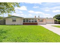 Charming single-story home featuring a lush green lawn and a welcoming facade at 321 Scotland Dr, Daytona Beach, FL 32117