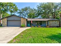 Charming single-story home with stone accents, a well-maintained lawn, and a welcoming blue front door at 35 Whippoorwill Ln, Ormond Beach, FL 32174