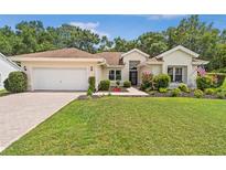 Charming single-story home with a well-manicured lawn, lush landscaping, and a welcoming front entrance at 11616 Sw 75Th Cir, Ocala, FL 34476