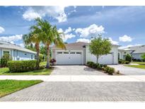 Charming exterior view of a home with a brick driveway, lush landscaping, and a two-car garage under a sunny sky at 206 St Somewhere Dr, Daytona Beach, FL 32124