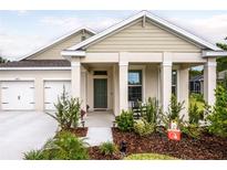 Charming home featuring a manicured lawn, covered porch, and a two-car garage, creating a welcoming curb appeal at 2861 Monaghan Dr, Ormond Beach, FL 32174