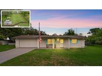 Charming single-story brick home featuring a well-manicured lawn and an attached two-car garage at 999 16Th St, Edgewater, FL 32132