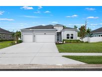 Charming one-story home with a three-car garage, manicured lawn, and elegant landscaping at 2137 Raglan Cir, Ormond Beach, FL 32174