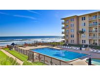 Inviting pool and sun deck with ocean view, offering relaxation and leisure by the beach at 4155 S Atlantic Ave # 204, New Smyrna Beach, FL 32169