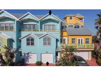 Charming blue and yellow townhomes with garages and balconies offer a coastal living experience at 3000 Ocean Shore Blvd # 18, Ormond Beach, FL 32176