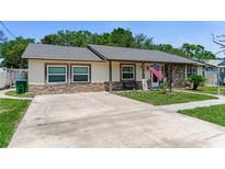 Charming single-story home featuring stone accents, neutral stucco, updated windows, and a spacious driveway at 466 Leland Dr, Deltona, FL 32725