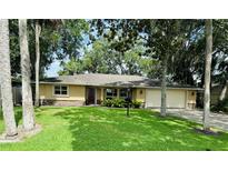 Charming single-story home with a well-manicured lawn, beautiful landscaping, and an attached two-car garage at 480 Palm Ave, Ormond Beach, FL 32174
