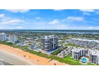 Expansive aerial view of a beachfront high-rise condominium with a pool, beach access and parking at 1239 Ocean Shore Blvd # 3C3, Ormond Beach, FL 32176