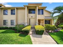 Inviting two-story condo with well-maintained landscaping and walkway leading to the front door at 133 Blue Heron Dr # D, Daytona Beach, FL 32119