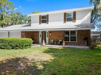 Charming two-story home featuring a welcoming front porch with brick accents and a well-maintained lawn at 506 Dorset Cir, South Daytona, FL 32119