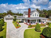 Stunning two-story home featuring a charming wrap-around porch and manicured landscaping at 96 Grove St, Ormond Beach, FL 32174