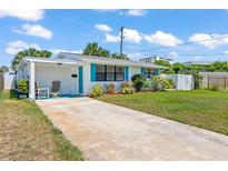 Charming single-story home featuring a well-maintained lawn, cozy carport, and vibrant turquoise shutters at 1 Beechwood Dr, Ormond Beach, FL 32176
