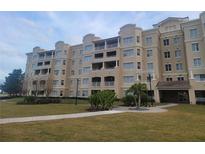 Tan multi-story building with balconies and landscaped grounds at 8495 Miracle Dr # 202, Champions Gate, FL 33896