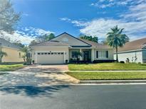 Single-story home with a two-car garage and landscaped yard at 2441 Prairie Dunes, Clermont, FL 34711