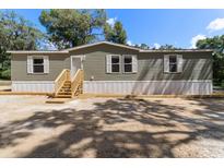 Single-wide manufactured home with wood siding and steps at 4422 Cr 690, Webster, FL 33597