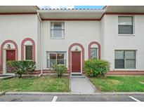 Inviting exterior of townhome with red door and well-manicured landscaping at 6299 River Run Pl # 198, Orlando, FL 32807