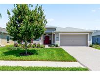 Single-story home with red door, attached garage, and well-manicured lawn at 3682 Arlington Ridge Blvd, Leesburg, FL 34748