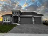 Beautiful single-Gathering home with a three-car garage and brick-paved driveway and stone design accents at 2311 Juniper Berry Dr, Minneola, FL 34715