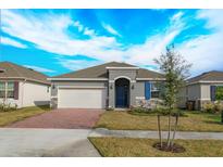 One-story home with gray siding, brick pavers, and a two-car garage at 5807 Wallis Ln, Saint Cloud, FL 34771