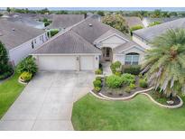 Charming single-story home featuring a well-manicured lawn and a two-car garage at 2410 Little Mountain Loop, The Villages, FL 32162