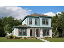 Charming two-story home featuring white stucco, teal trim, manicured lawn, and a welcoming entrance at 10430 Pearson Ave, Orlando, FL 32827